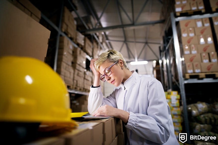 Blockchain in supply chain: A female worker counting boxes in a warehouse.